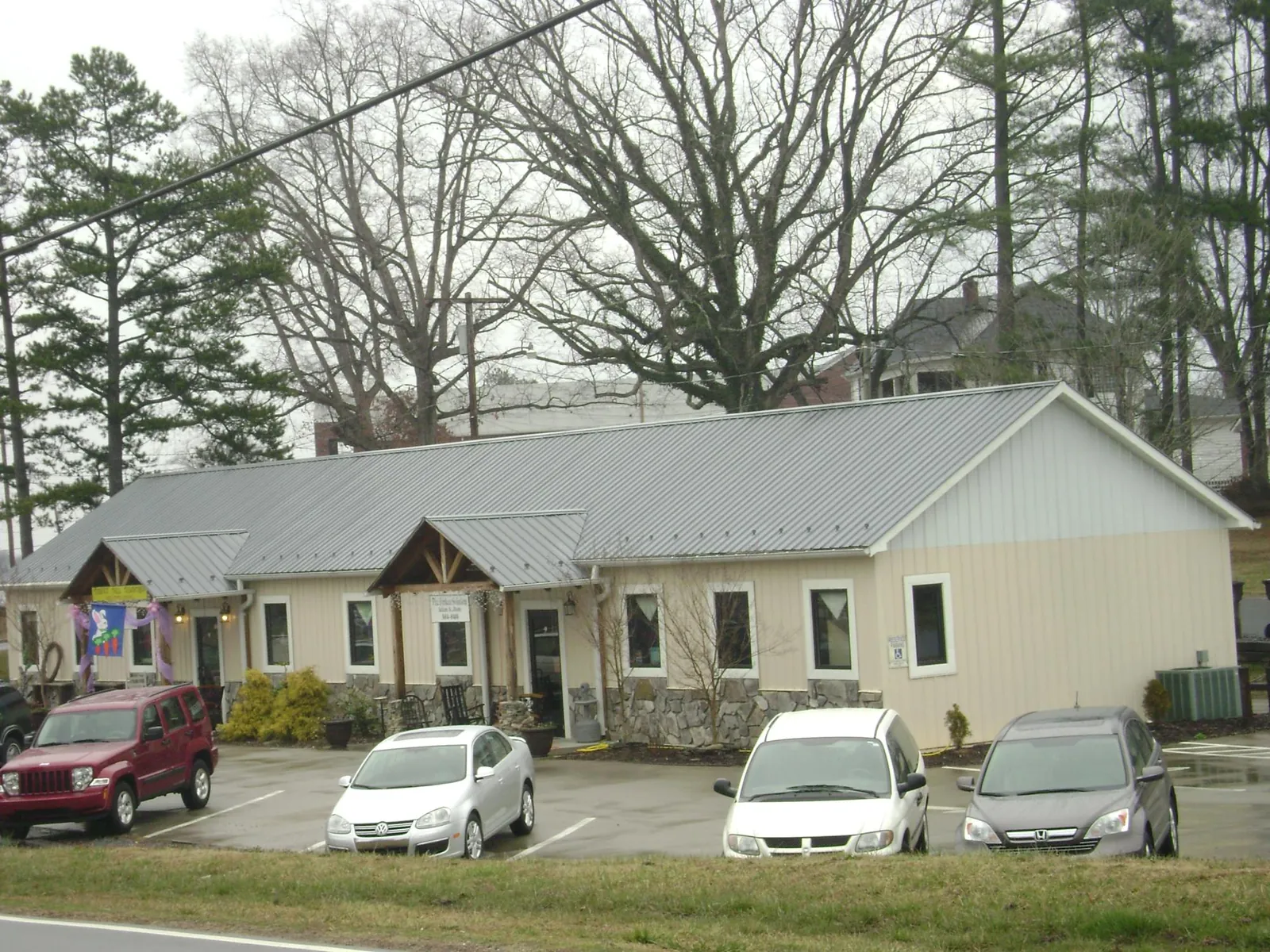Gray metal roof with timber entry brackets on a small commercial building in Kansas City